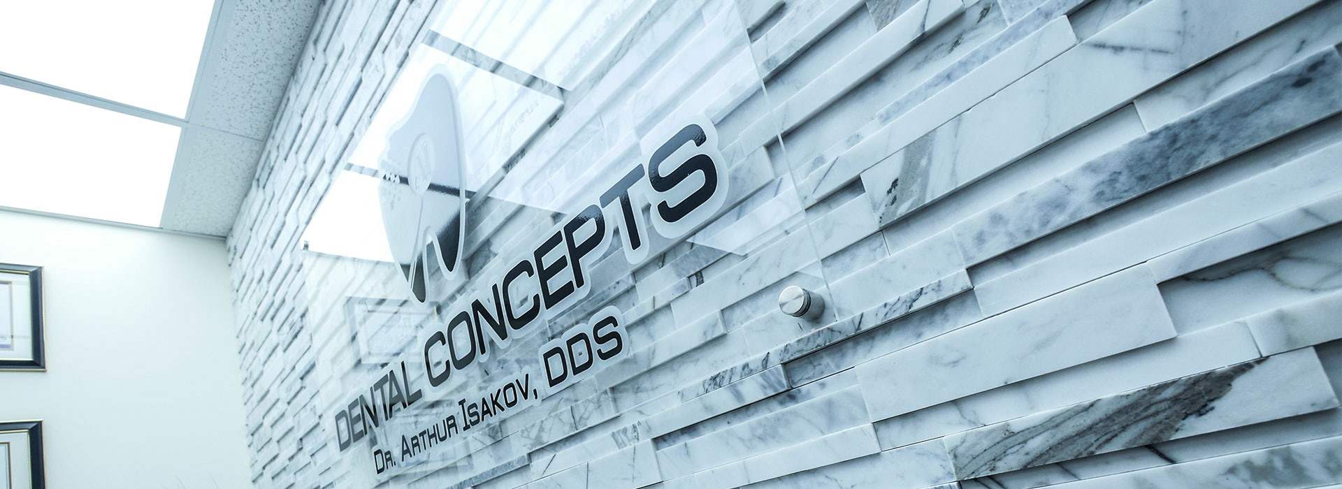 The image shows a professional setting with a modern wall featuring a logo and design elements, likely representing a dental office named  Vision Concepts.