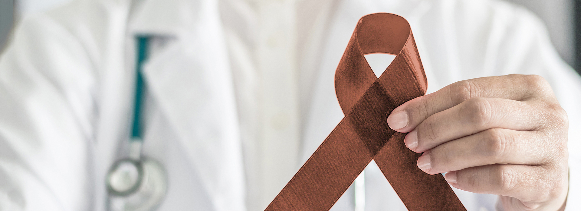 The image shows a healthcare professional holding a red ribbon with a white cross symbolizing the AIDS awareness campaign.